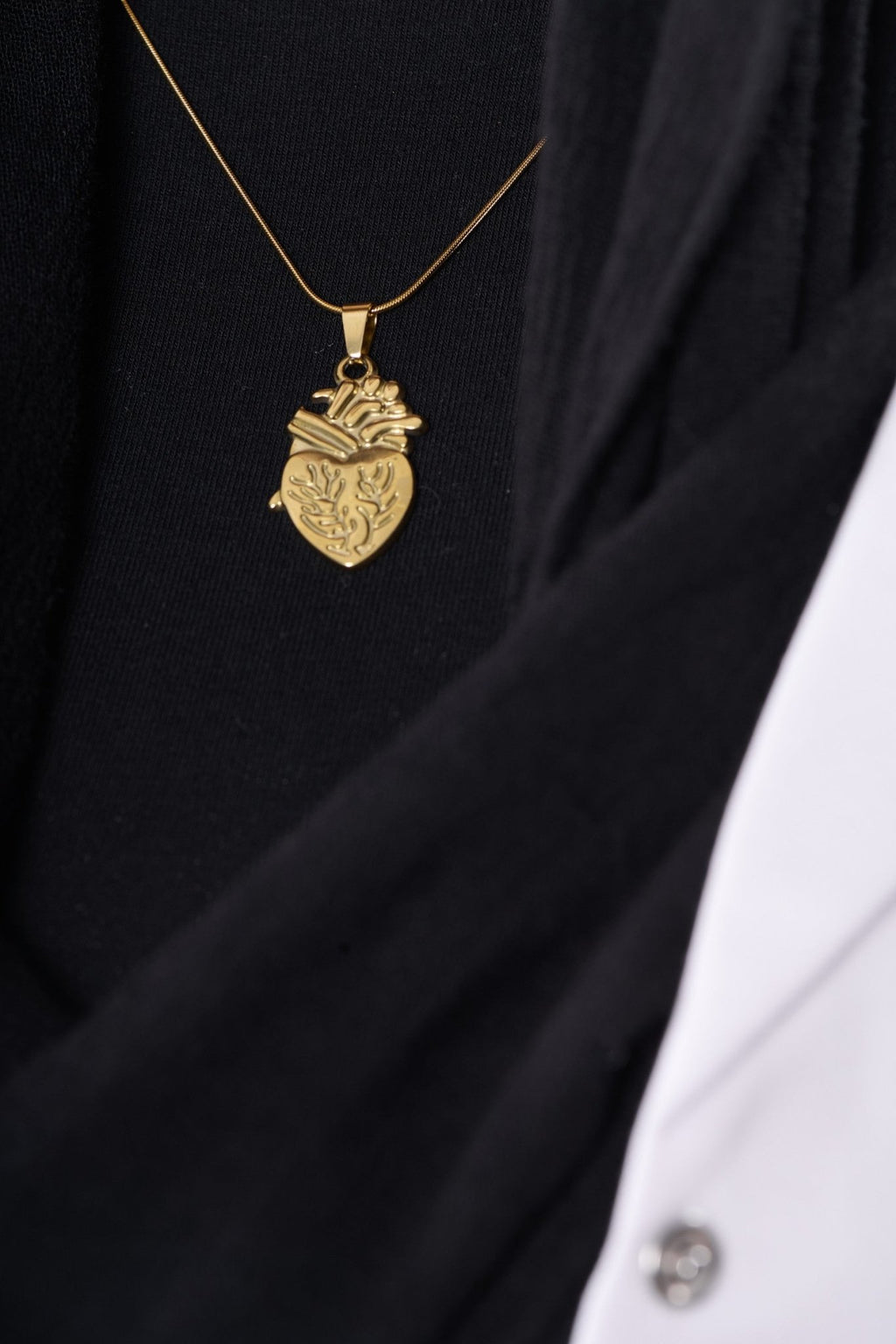 Engraved anatomical heart pendant on model, close up