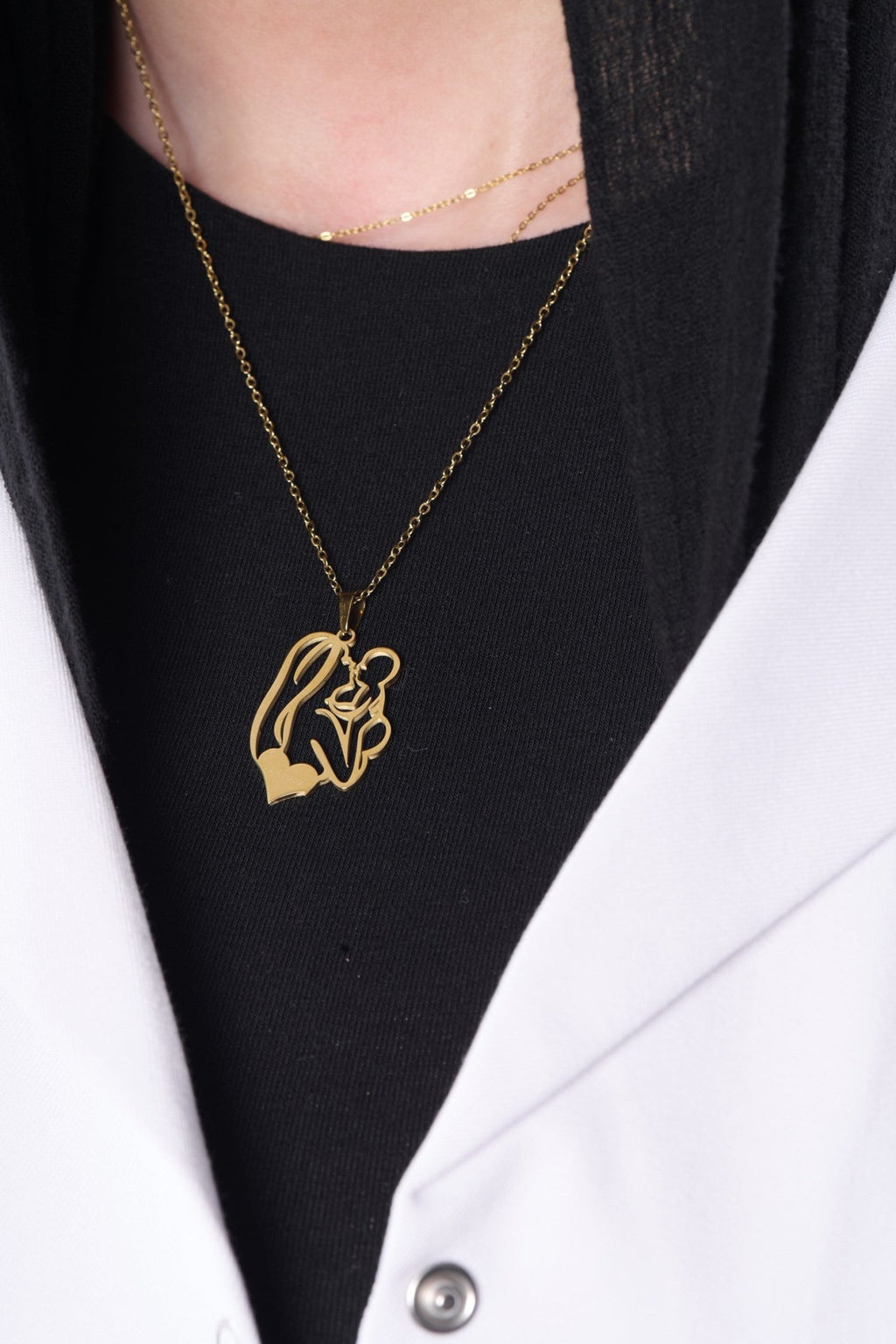 Gold mother and child pendant worn with a BALTO lab coat