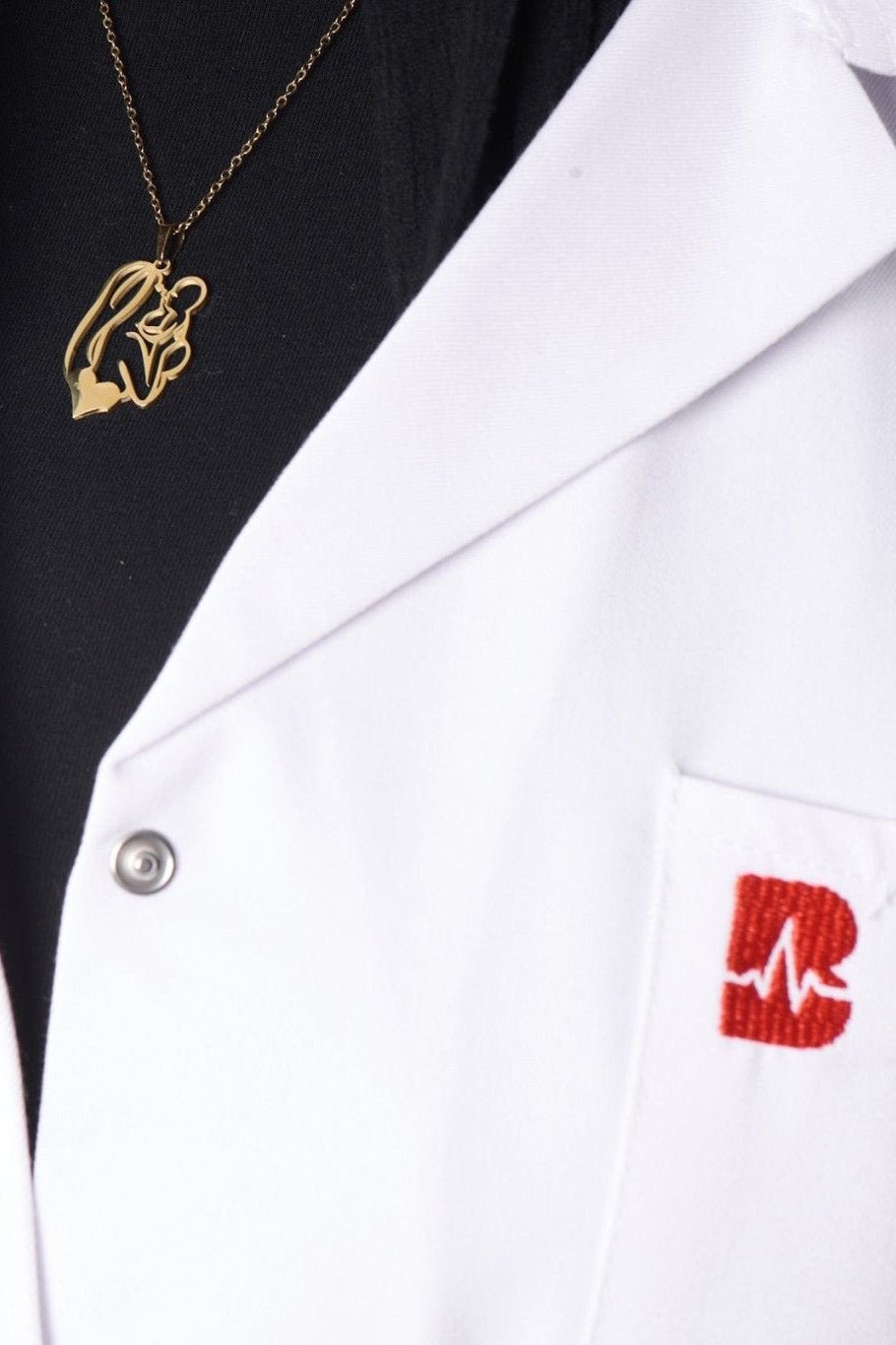Gold mother and child pendant on model, BALTO lab coat