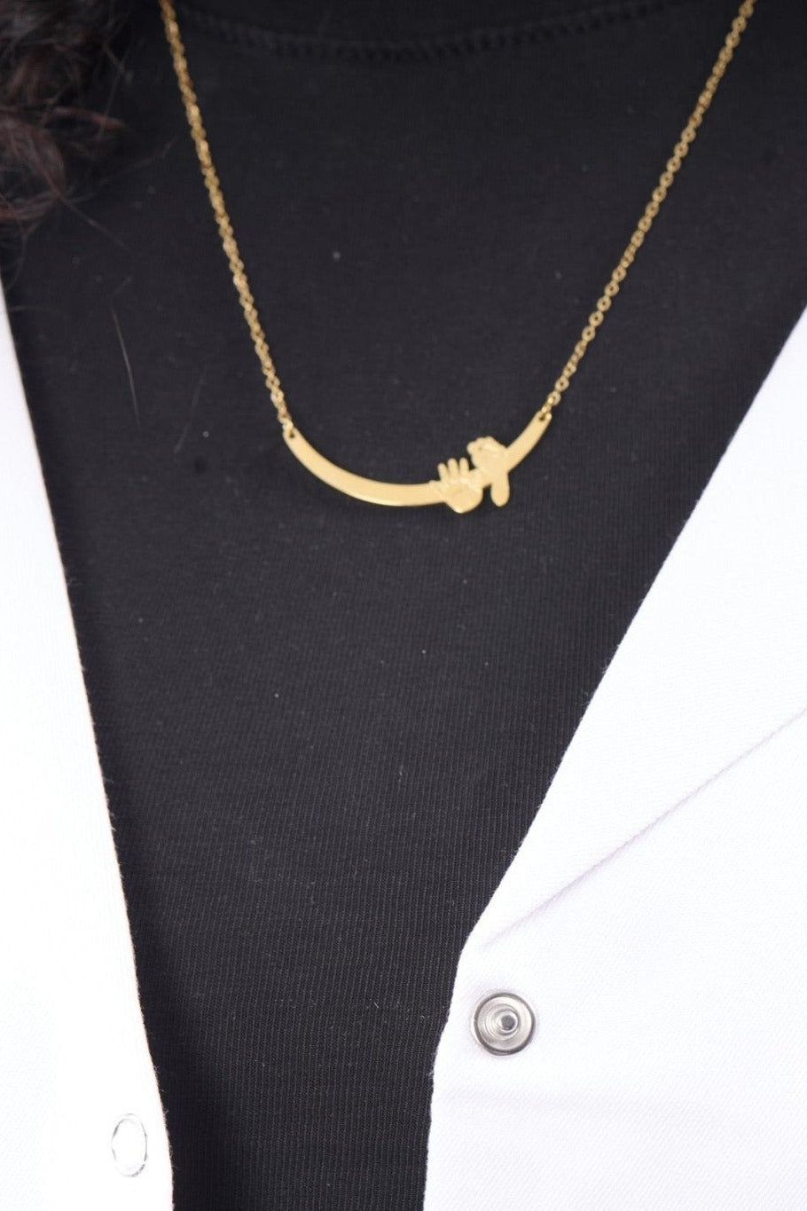 Hand and foot necklace on model, BALTO lab coat