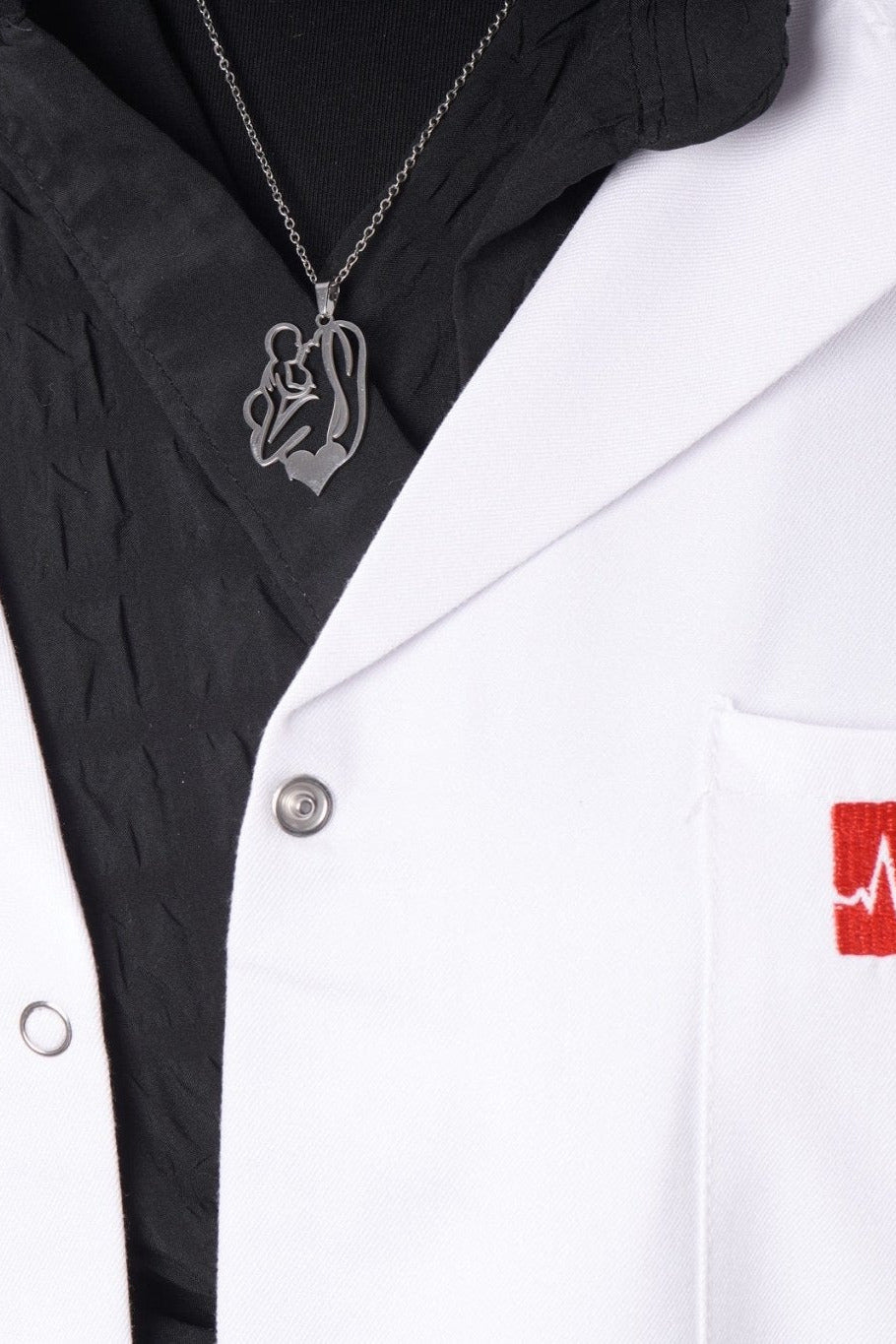 Silver mother and child pendant worn with a BALTO lab coat